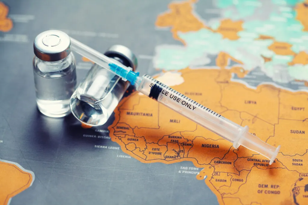 seringa medica com uma agulha e um bollte com vacina no mapa mundo