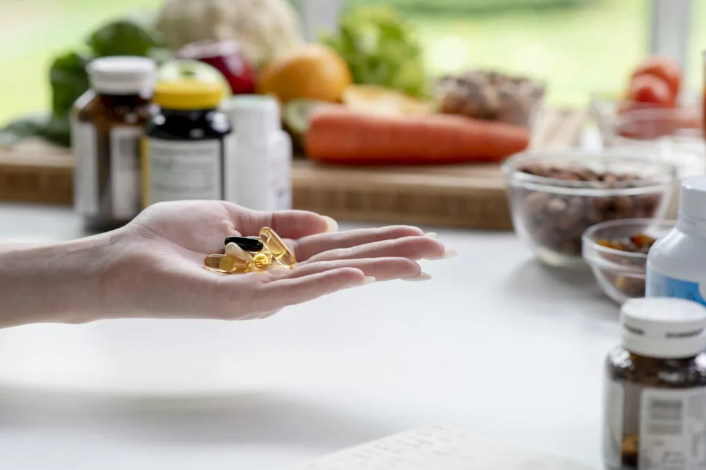 woman professional nutritionist checking dietary supplements hand surrounded by variety fruits nuts vegetables dietary supplements table 2.jpg